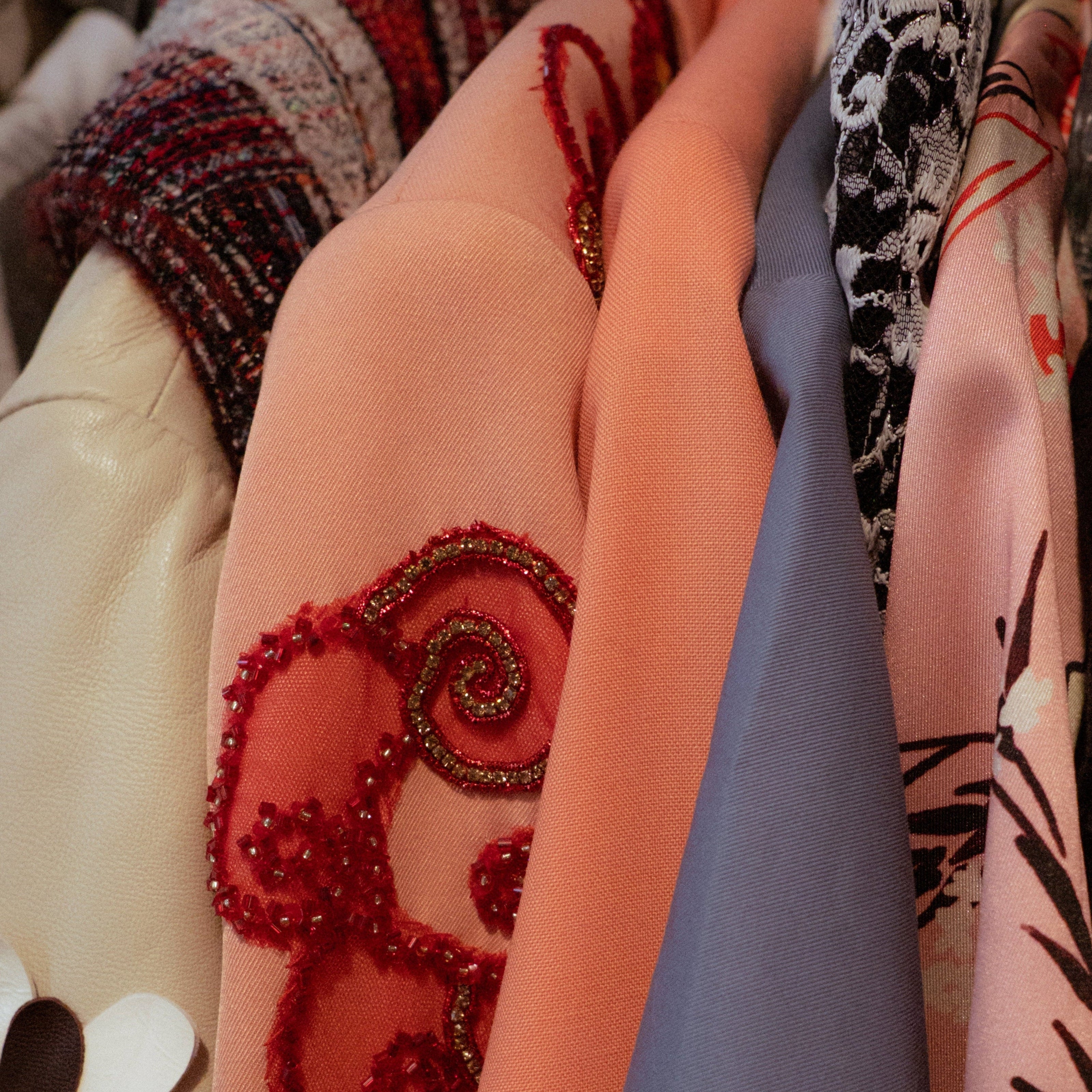 Close-up of various patterned fabrics with embroidery and designs.
